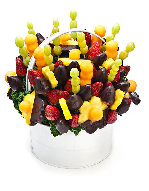 Lovely tropical fruit bouquet arrangement in a white basket Edible bouquet made out of fruit dipped in chocolate. Isolated on white with soft shadow. arrangement stock pictures, royalty-free photos & images