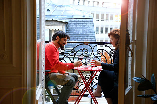 Loving couple having drink on a balcony in Paris stock photo