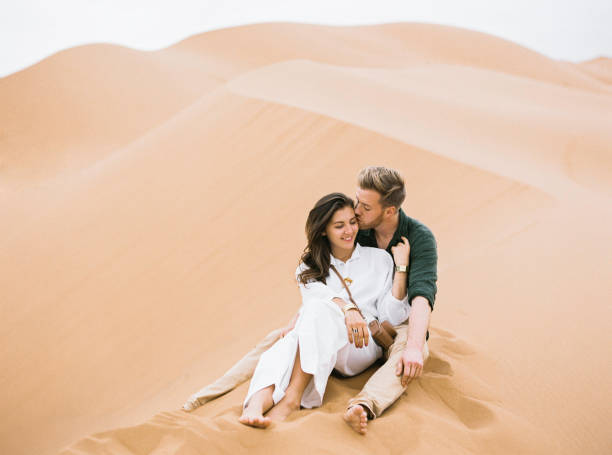 Loving couple in Sahara Desert. Young couple enjoying the sunset in dunes. Romantic traveler walking on the Sahara desert. Adventure travel lifestyle concept. hot arab women stock pictures, royalty-free photos & images