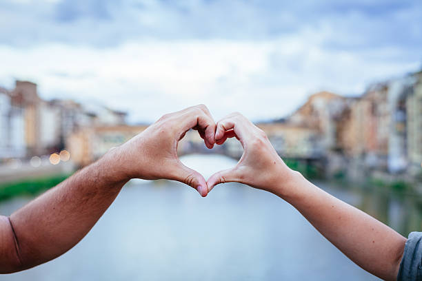 Loving couple making heart with her hands in Florence stock photo