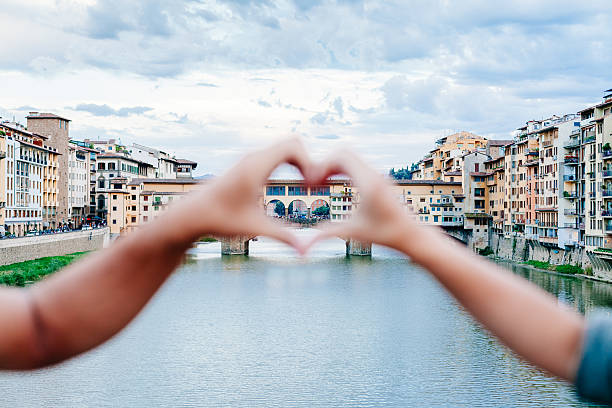 Loving couple making heart with her hands in Florence Loving couple making heart with their hands in front of Ponte Vecchio, Florence florence italy photos stock pictures, royalty-free photos & images