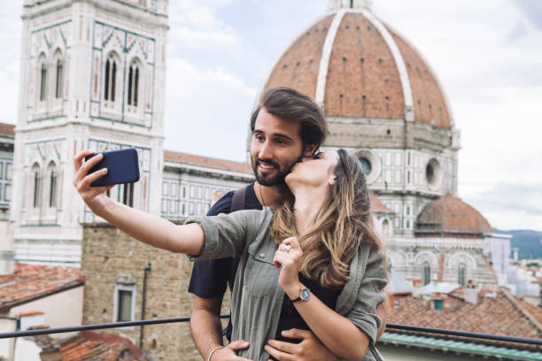 Loving couple taking a selfie in front of the church Santa Maria del Fiore, Florence Cathedral stock photo