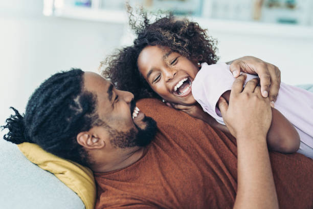 Loving family moments Happy African ethnicity father playing with his daughter at home fathers day stock pictures, royalty-free photos & images