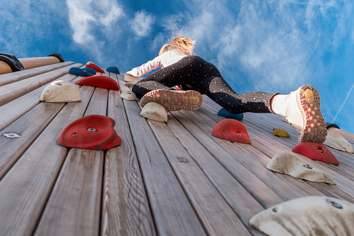 Low Angle View of Girl Climbing Rock Wall Outdoors
