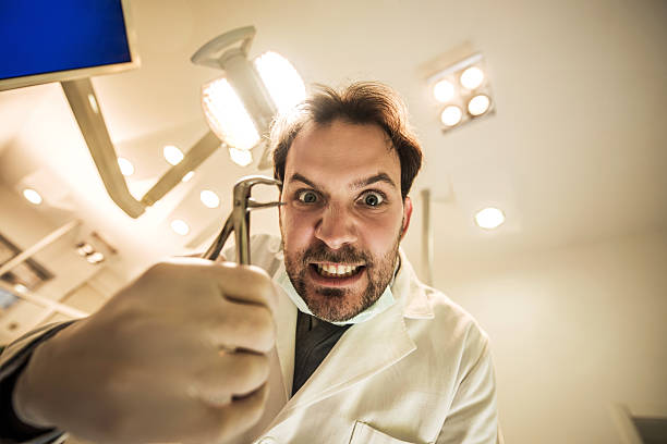 [Image: low-angle-view-of-spooky-male-dentist-wi...DR2H5n774=]