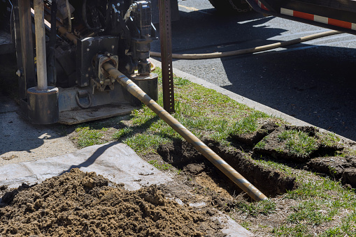 Low angle view of trenchless laying of communications, fiber optic and water pipes with horizontal directional drilling technology machine work process