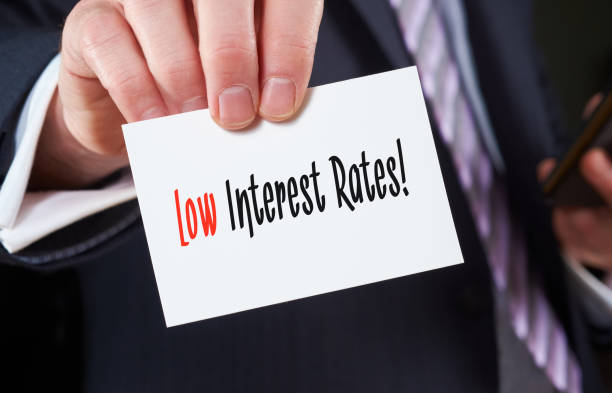 Low Interest Rates concept A businessman holding a business card with the words, Low Interest Rates, written on it. low stock pictures, royalty-free photos & images