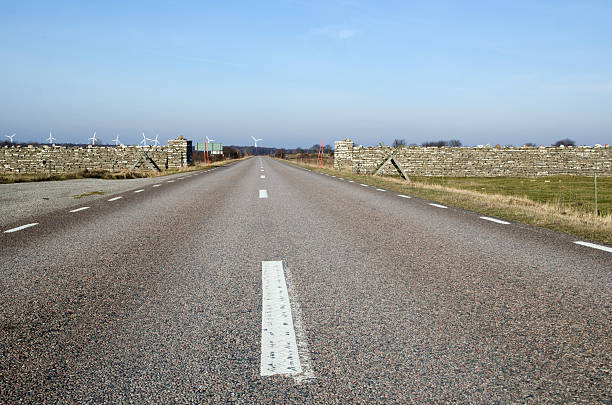 Low perspective at road with windmills ahead stock photo