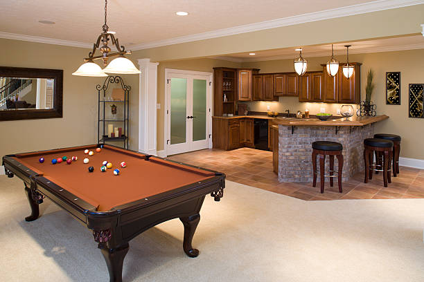 Lower level game room and bar in residential home. Recently finished residential lower level game room and bar with pool table and stools. basement photos stock pictures, royalty-free photos & images
