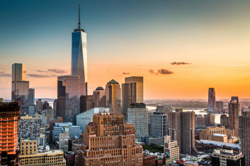 Lower Manhattan skyline at sunset with Freedom Tower standing tall above the skyline