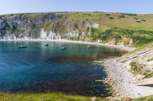 Lulworth Cove on the Jurassic Coast Dorset World Heritage Site Lulworth cove on a sunny summer late afternoon. jurassic world stock pictures, royalty-free photos & images