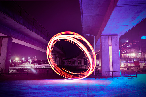 A ring of light lights up at night in the middle of an industrial area