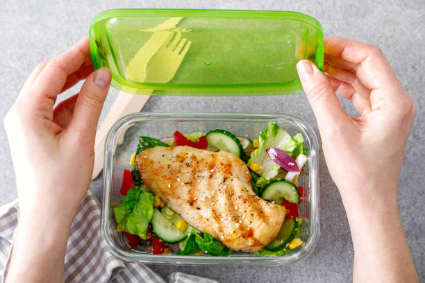 lunch box of vegetable salad with grilled chicken breast stock photo