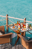 Luxurious Breakfast table with colorful dishes and juices by the Sea in Maldives