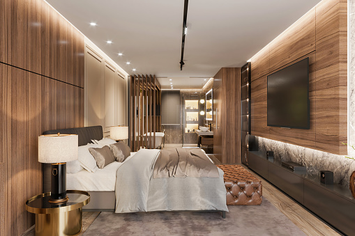 Luxury apartment bedroom interior with bathroom in the background. Large pastel colored bed, velvet carpet, night table with lamp, wooden walls, TV set, LED light and glass door in the background. Template for copy space. Render.