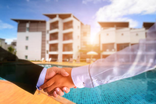luxury building resort background. Double exposure of Two businessman shaking hands and Blurred lluxury building resort background. Concept for business and propperty . Commercial Property Investment stock pictures, royalty-free photos & images