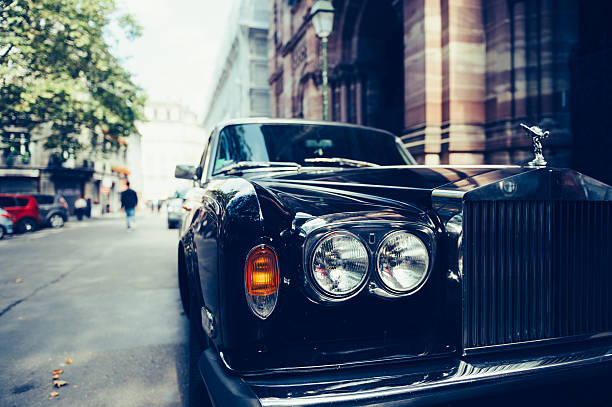 Luxury Rolls Royce car on Paris Street Paris, France - September 12, 2016: Front view of Exclusive Luxury Rolls-Royce car limousine parked in city during fashion wedding vip event waiting for passenger. Rolls-Royce Limited is a British car-manufacturing and, later, aero-engine manufacturing company founded by Charles Stewart Rolls and Sir Frederick Henry Royce on 15 March 1906 as the result of a partnership formed in 1904. luxury car stock pictures, royalty-free photos & images