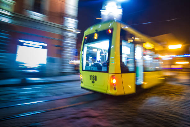 львовская ночь размыта трамваем на исторических красивых улицах с глубоким красочным светом - manchester united стоковые фото и изображения