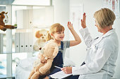 Shot of an adorable little girl giving her doctor a high five during a checkup