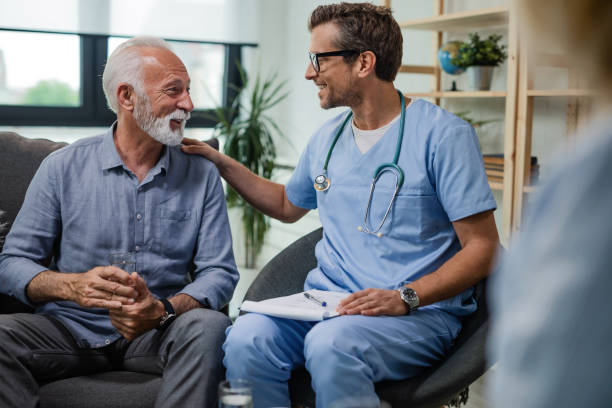 I'm glad to see you doing well! Happy doctor talking to senior male patient while being in a home visit. mature adult photos stock pictures, royalty-free photos & images