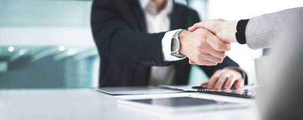 I'm glad we could settle on something Closeup shot of two businesspeople shaking hands in an office business meeting photos stock pictures, royalty-free photos & images