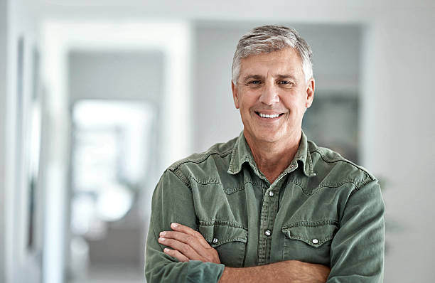 I’m still in the prime of my life Portrait of a mature man standing with his arms crossed at home mature men stock pictures, royalty-free photos & images