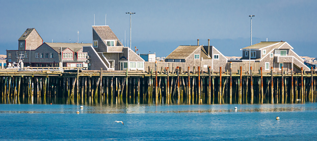 A row of unique and architecturally interesting condominiums built on the pilings of MacMillan pier in Provincetown, Massachusetts offer a vacation location close to everything this tip of Cape Cod village has to offer.