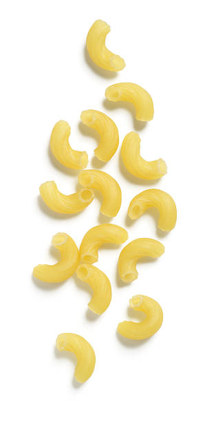 Macaroni or Elbow Pasta on White Background Dry macaroni (or elbow) pasta isolated on 255 white. macaroni stock pictures, royalty-free photos & images