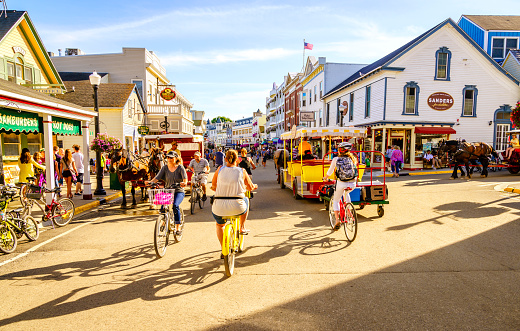 Mackinac Island, Michigan, August 8, 2016: Vacationers take on Market Street on Mackinac Island that is lined with shops and restaurants. No motorized vehicles are allowed on the island.
