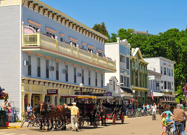 Mackinac street Mackinac Island, MI, USA - June 26, 2014: Main Street on Mackinac Island is thronged with tourists on a bright summer day and is the point of embarkation for many of the island carriage tours. mackinac island stock pictures, royalty-free photos & images