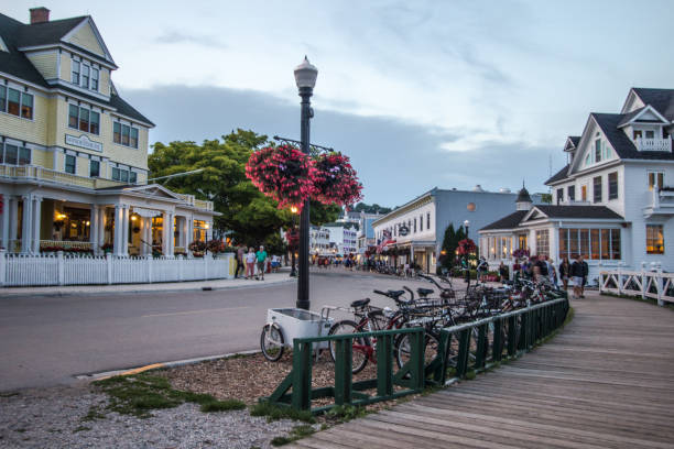 Mackinaw Island Street Scene Mackinaw City, Michigan, USA - August 8, 2018: Horse and carriage and bicycles line the streets of Mackinaw Island. The popular island has a ban on automobiles and and transportation is limited to foot, bike or horse. mackinac island stock pictures, royalty-free photos & images