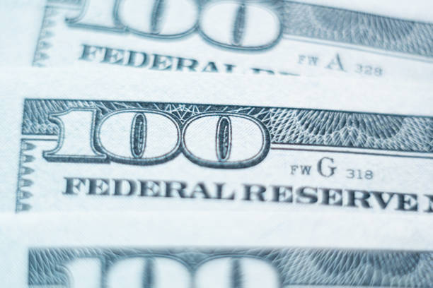 Macro closeup of one hundred American dollars banknote Macro closeup of American Federal Reserve banknote with one hundred dollars number in focus federal reserve stock pictures, royalty-free photos & images