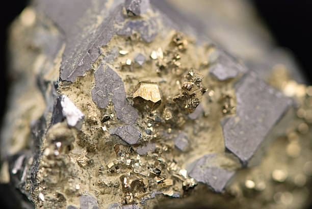 macro picture of a raw golden nugget found on a mine - mineraal stockfoto's en -beelden