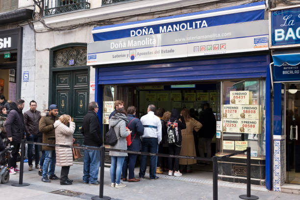 Madrid - People lined up outside the Dona Manolita lottery shop to buy a Christmas Lottery tickets in calle del Carmen. stock photo