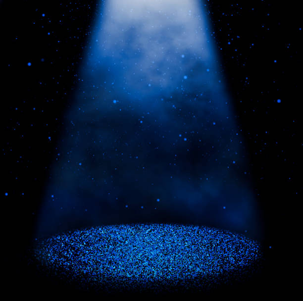 Magic blue sparkling stage Twinkling blue glitter falling on the stage illuminated with one spot light staging light stock pictures, royalty-free photos & images