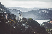 Beautiful Idylllic snowy and fogy landscape view of the Bavarian mountains, Neuschwanstein and lake in Fussen, Bavaria, Germany