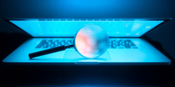 Magnifying glass in the laptop in the dark stock photo