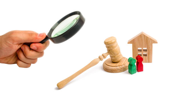 Magnifying glass is looking at the Wooden apartment house with keys and a judge hammer on a white background. The concept of the trial of an apartment house. Confiscation of property. Magnifying glass is looking at the Wooden apartment house with keys and a judge hammer on a white background. The concept of the trial of an apartment house. Confiscation of property. house auctions near me stock pictures, royalty-free photos & images