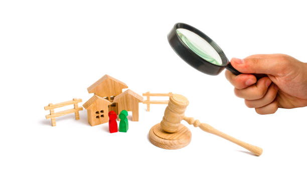 Magnifying glass is looking at the Wooden apartment house with people, keys and a judge hammer on a white background. The concept of laws and regulations for tenants and owners of a building. . Magnifying glass is looking at the Wooden apartment house with people, keys and a judge hammer on a white background. The concept of laws and regulations for tenants and owners of a building. . house auctions near me stock pictures, royalty-free photos & images