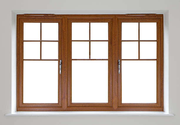 Mahogany double glazed windows a modern window frame from an expensive new house made from solid mahogany with double glazed sealed units, set in a recessed wall.  The background image has been blanked out leaving a clipping path to enable placing a new background or colour of choice behind the window. The surrounding wall and sill are neutral.  window frame stock pictures, royalty-free photos & images
