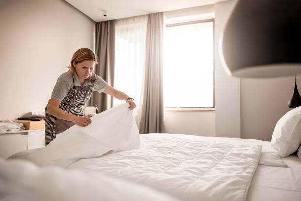 Sirvienta trabajando en un hotel haciendo las sábanas - foto de stock
