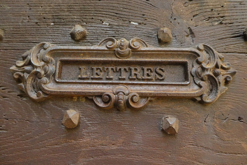 letters and metal slot with the mention letters to deposit them there. All installed in a wooden door at home. Photo taken from the street