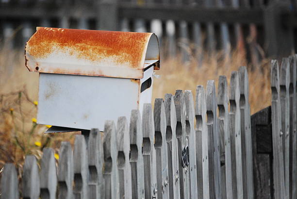Mailbox A weathered mailbox in a yard. rusty fence stock pictures, royalty-free photos & images