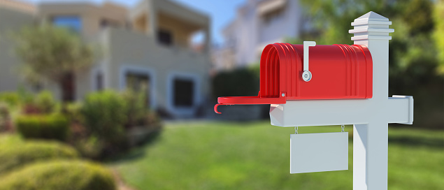 Mailbox red color on white post with blank street number tag, blur house garden background. Empty retro mail box with open door and raised flag. 3d illustration