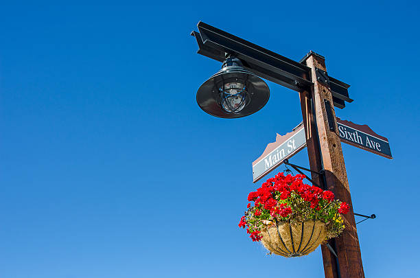 main street sign with a basket of geraniums - hangplant wood stockfoto's en -beelden