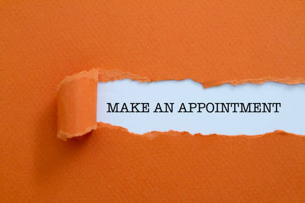 Make an appointment written under torn paper. stock photo