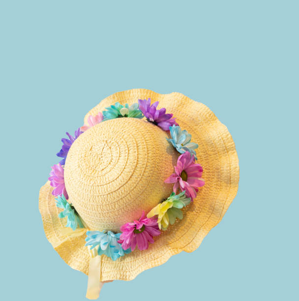 Make Your Own Easter Bonnet with Fresh Flowers Straw hat is decorated with fresh flowers on a plain background easter sunday stock pictures, royalty-free photos & images