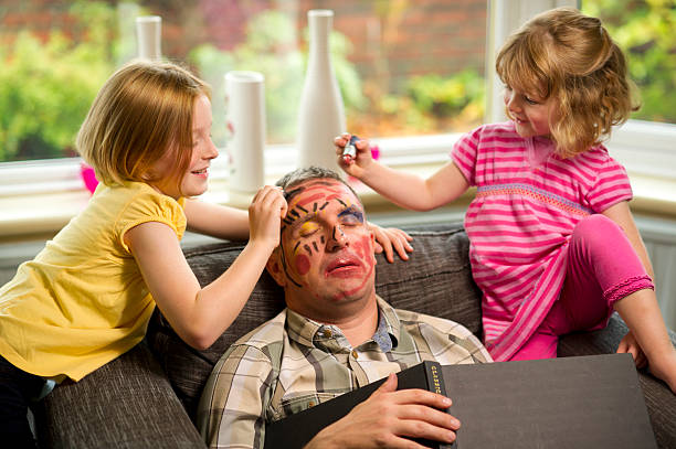 make-up mischief dad falls asleep and the children get out the make up box** book spine has the word 'classic' which is not the logo or company name ** child behaving badly stock pictures, royalty-free photos & images