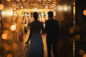 Rearview shot of a young couple arriving hand in hand at their wedding reception