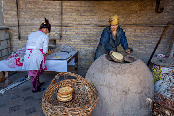 Making Bread, Khiva, Uzbekistan Khiva, Uzbekistan - October 16, 2018: Uzbek women make tandoori bread in Khiva, Uzbekistan. samarkand stock pictures, royalty-free photos & images